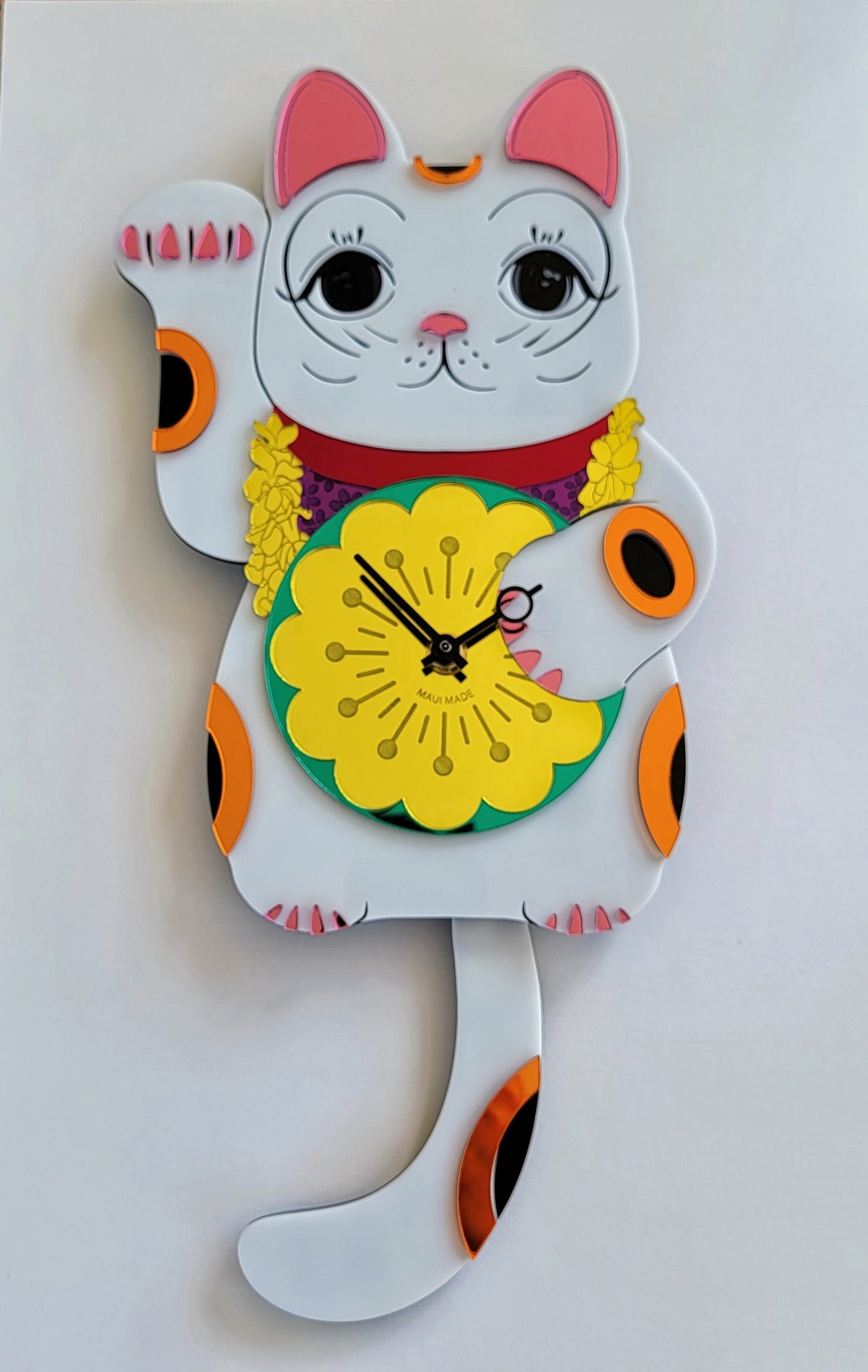 A colorful wall clock featuring a stylized cat with a pendulum tail, predominantly white with orange and pink accents, and a yellow flower-shaped clock face.